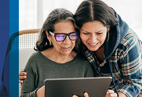 Middle aged woman looking at a tablet with her mother