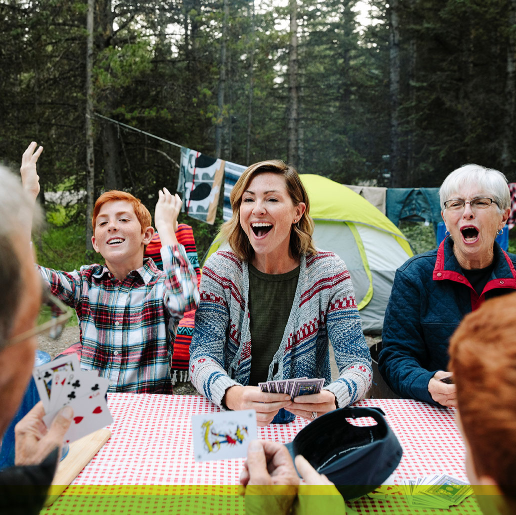 Family playing cards while camping